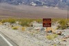 A sign on the side of a desert road reads, "Caution! Extreme Heat Danger"