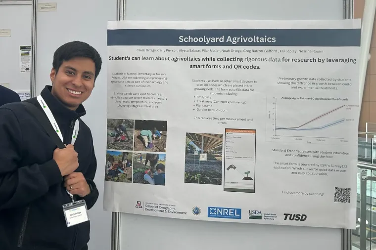 Caleb Ortega smiles next to his project poster.