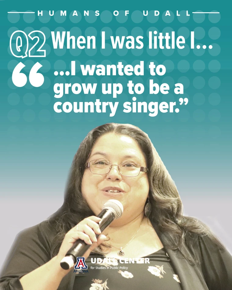 Naomi smiles while speaking into a microphone.