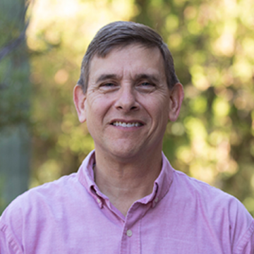 A portrait of Professor David Pietz outdoors in a pink button-up shirt.