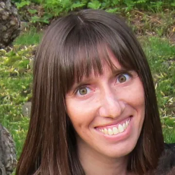 A close-up outdoor portrait of Roth-Gordon with what appears to be grass and ivy behind her.